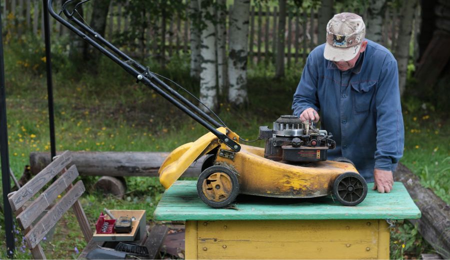 A man carefully adjusts a lawn mower engine, aiming for peak performance and efficiency